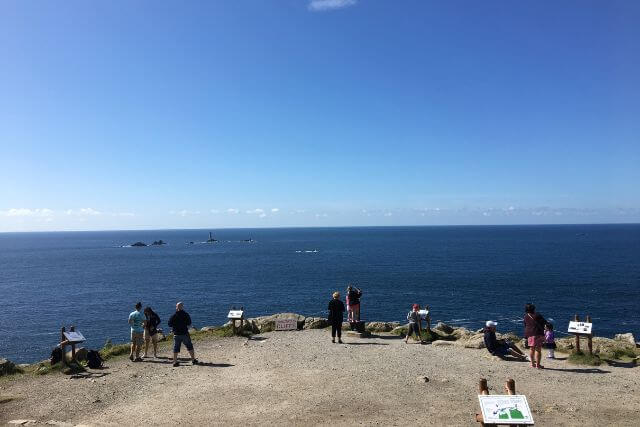 Visitors looking out over the coast at Land's End.