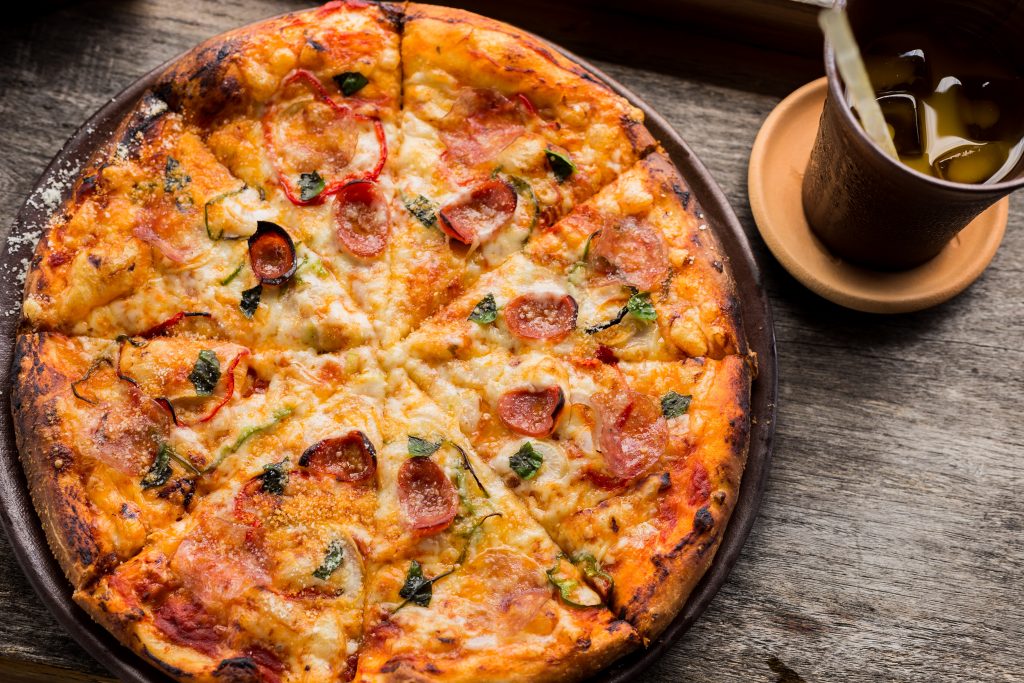 whole marguerita pizza on a wooden table