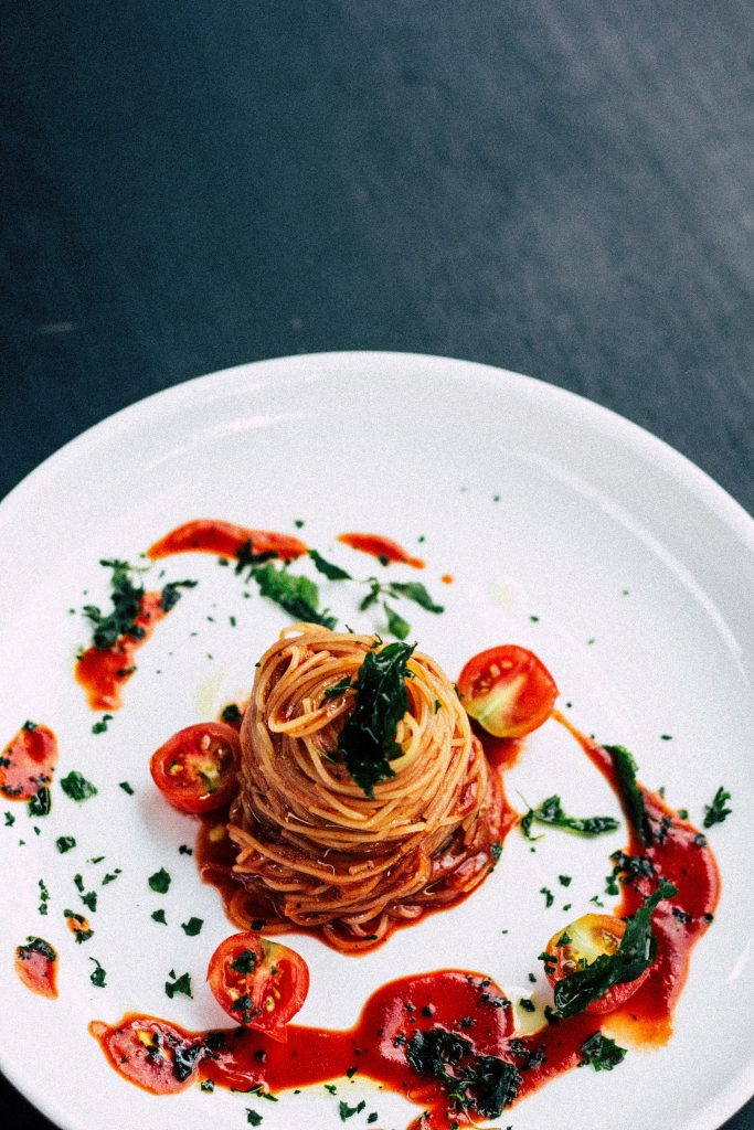 White Plate of Spaghetti ao Sugo decorated with cherry tomatoes from one of the Italian Restaurants in St Ives