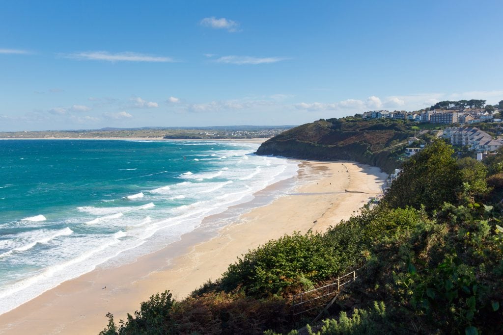 A view of Carbis Bay beach from the south west coastal path on a sunny day.