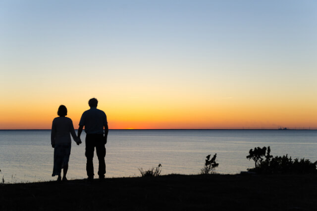 Silhouette of a couple watching a sunset on the coast.