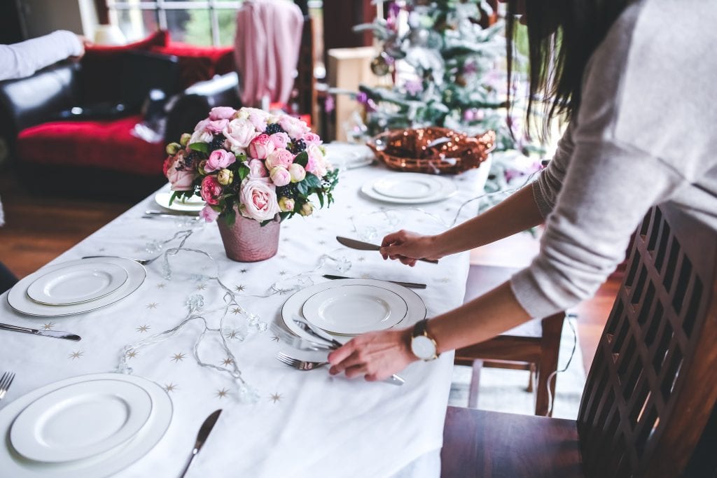 Woman laying cutlery for restaurant Christmas dinner