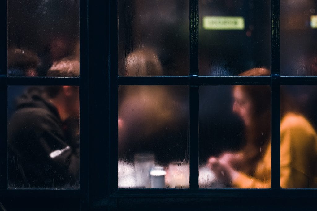 Woman and man in restaurant behind condensation in glass