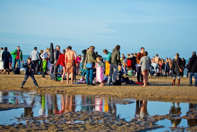 Group of people on beach in winter.