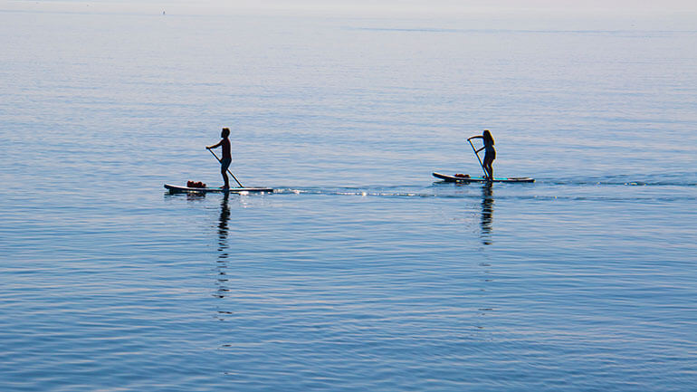 couple paddleboarding in Cornwall