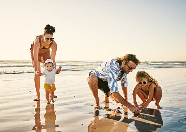 Family playing on beach - self catering guide