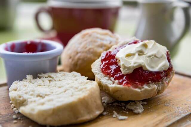 A scone with jam and cream on, traditionally Cornish cream tea.