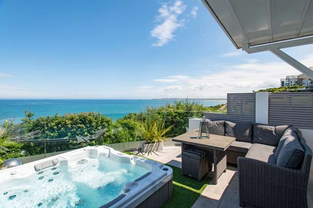 Hot tub and sunny outdoor eating area on a balcony in St Ives, with a sea view in the background