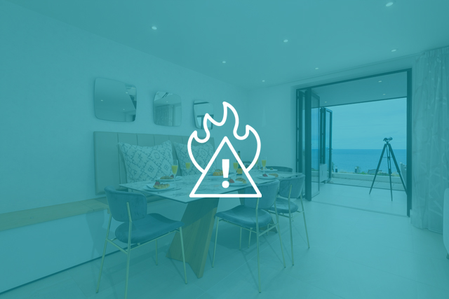 Fire hazard icon overlaid on an interior shot of a Carbis Bay Holidays self catering property