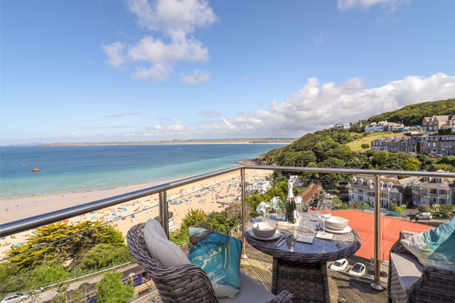 View over a sun soaked beach from the balcony of a holiday apartment